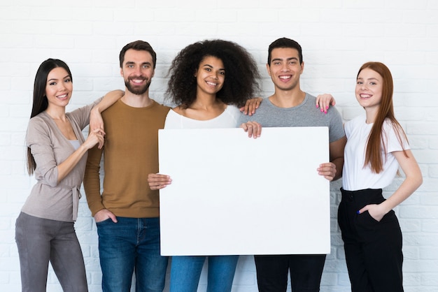 Free photo group of young people holding a sign