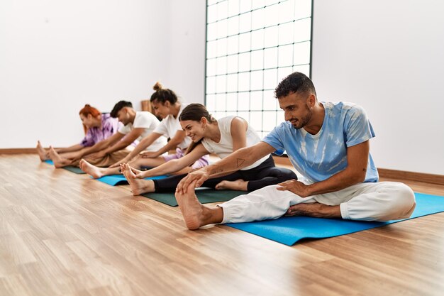 Group of young people smiling happy training yoga at sport center