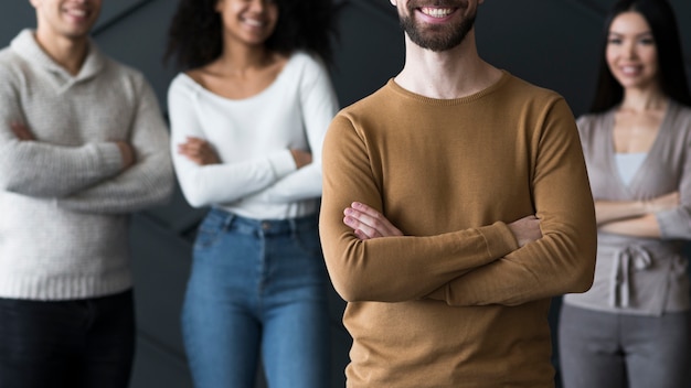 Foto gratuita gruppo di giovani in piedi con le braccia incrociate