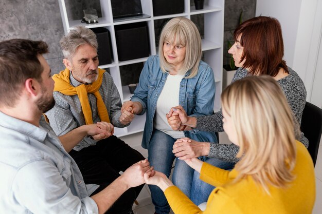 Sessione di terapia Grup tenendosi per mano