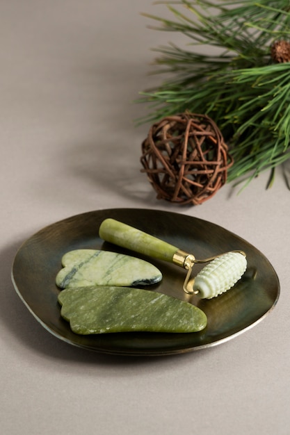 Gua sha and face roller on plate arrangement