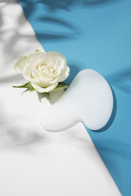 Free photo gua sha and flower arrangement high angle