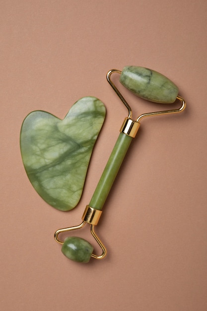 Free photo gua sha and roller arrangement flat lay