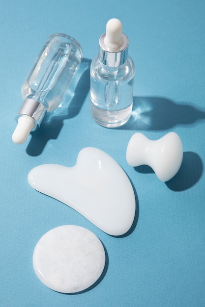 Gua sha and serum bottles arrangement high angle