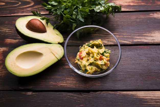 Free photo guacamole in bowl and avocados near herbs