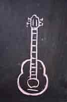 Free photo guitar drawn on a black slate