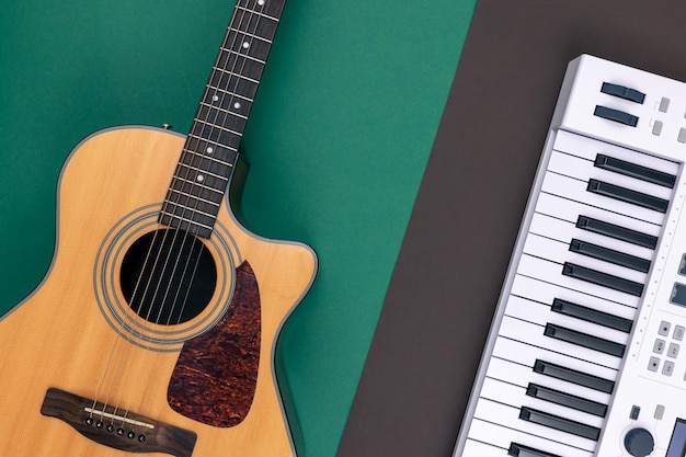 Foto gratuita chitarra e tasti musicalisu una vista dall'alto di sfondo colorato