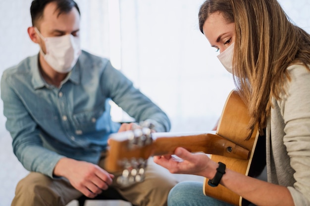 Foto gratuita insegnante di chitarra che supervisiona la donna che impara a suonare