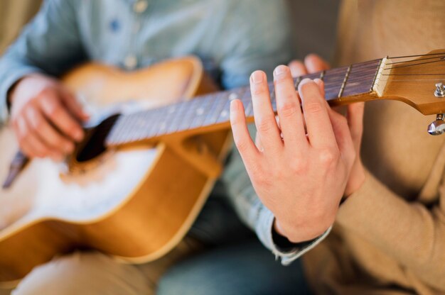 Guitar teacher showing student how to play the instrument