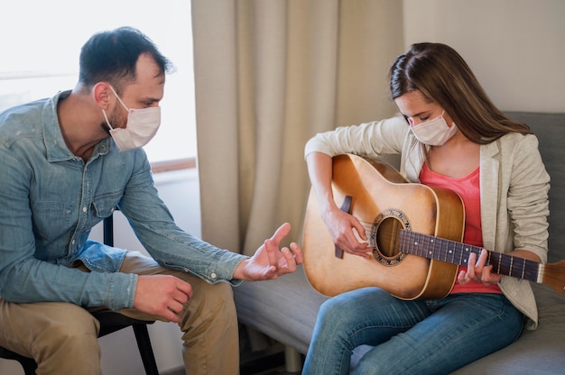 Guitar teacher tutoring woman at home