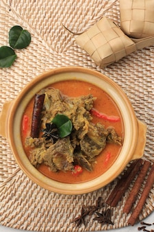 Gulai sapi gulai sapi - это традиционное блюдо из говядины карри из паданга, западная суматера, индонезия. подается за столом с чашей и кетупат лебаран. меню для ид аль адха (idul adha)