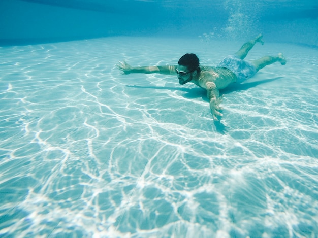 Foto gratuita immersione del ragazzo in piscina