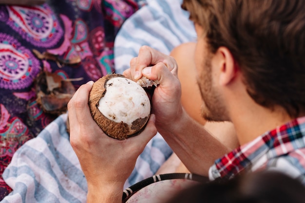 Foto gratuita guy mangiare la noce di cocco in spiaggia