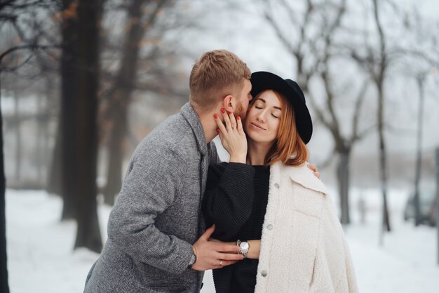 The guy and the girl are resting in the winter forest.