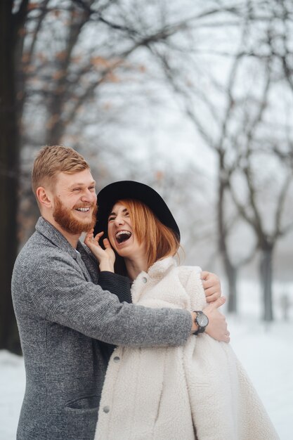 The guy and the girl are resting in the winter forest.