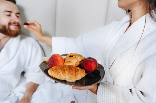 The guy and the girl bathrobe, girl feeds the guy fruit