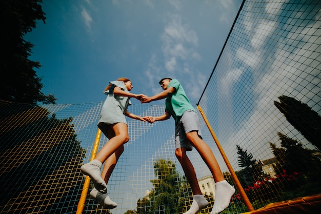 Guy and girl jumping holding hands