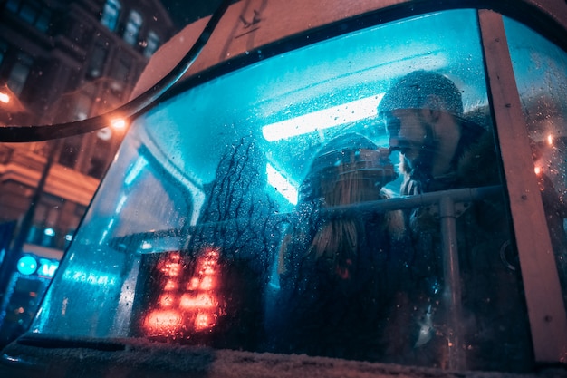 The guy and the girl kiss on the tram behind the misted glass