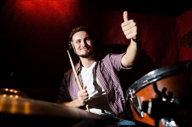 Guy holding a drumstick and giving a thumbs up