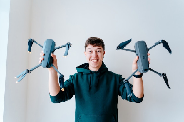 Guy holds two quadrocopters against a wall