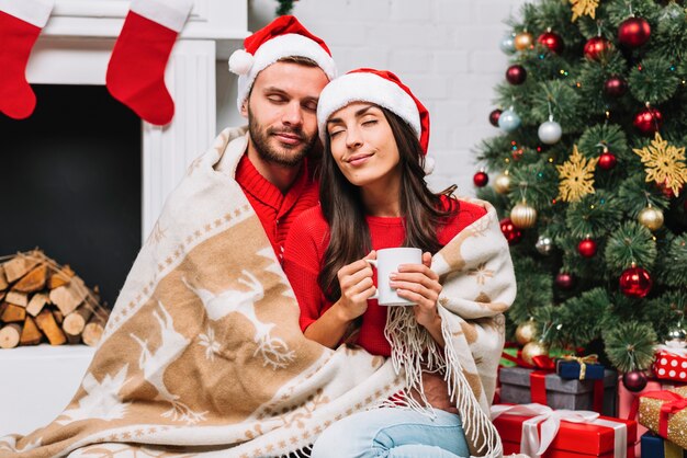 Guy hugging lady with cup and closed eyes