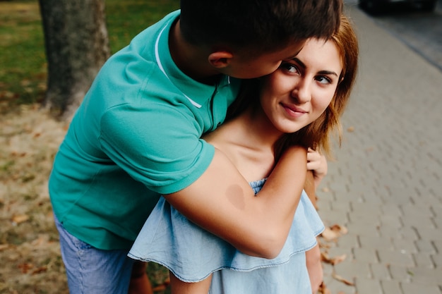 Free photo guy hugging redhead girl standing outdoors