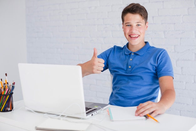 Free photo guy making thumb up gesture at desk