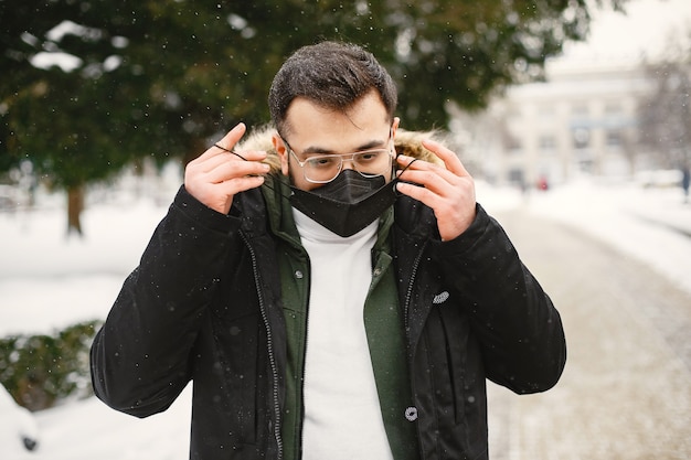 Guy in a mask. Indian in warm clothes. Man on street in winter.