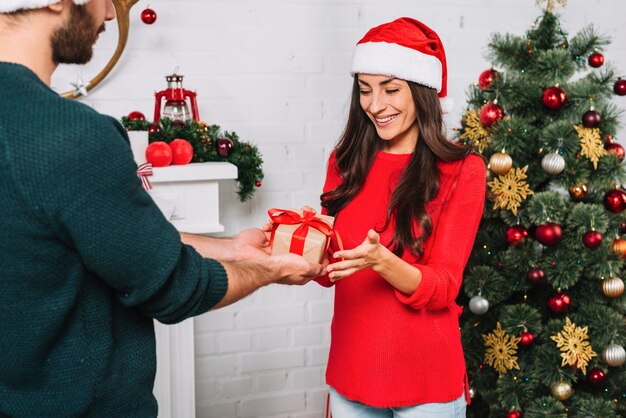 Guy presenting gift for happy lady