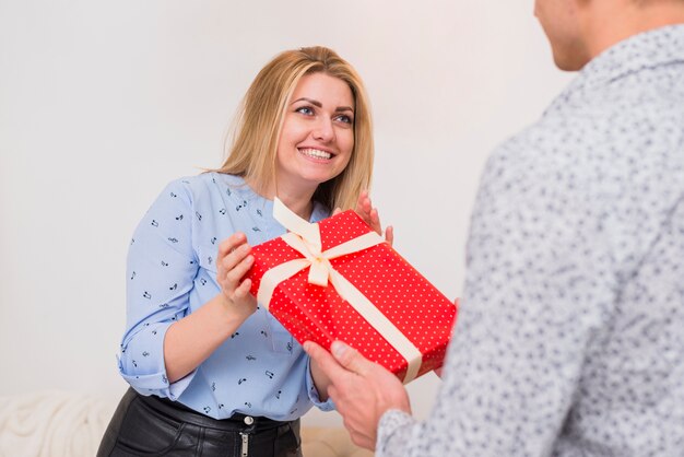 Guy presenting gift to happy lady