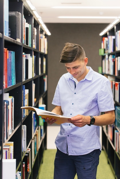 Guy reading book in library