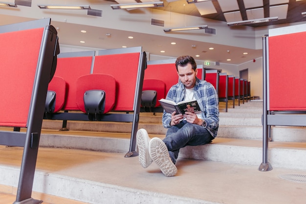 Guy reading book sitting on steps