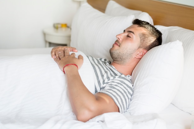 Guy sleeping with hands on his chest