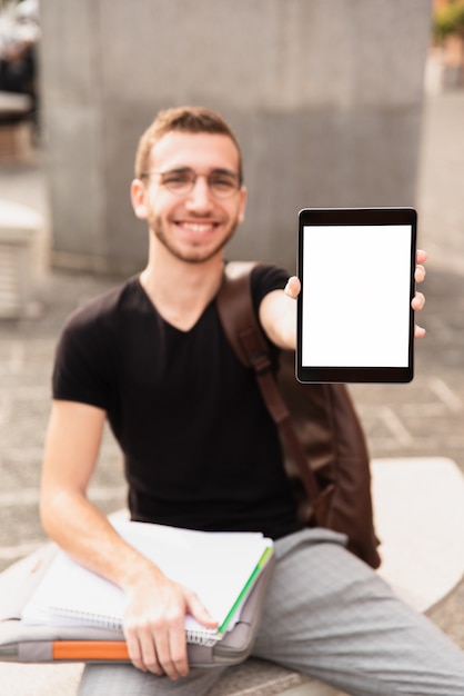 Free photo guy smiling and showing his tablet