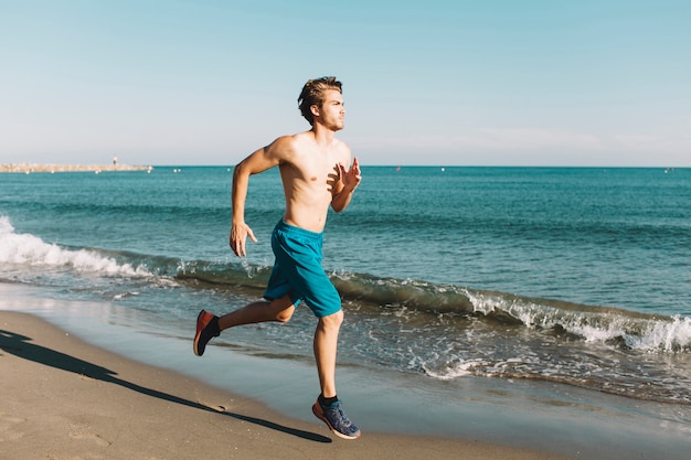 Guy sprinting at the beach