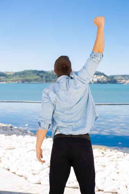 guy standing at sea and celebrating success