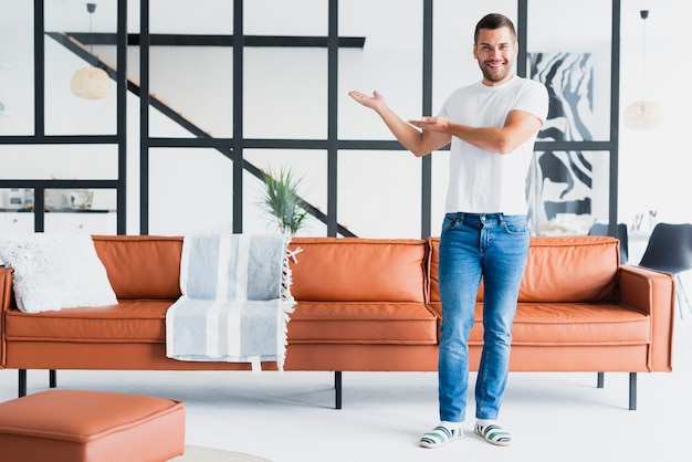 Guy standing and showing his living room