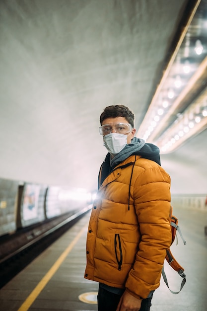 Guy standing at station in medical protective mask on his face