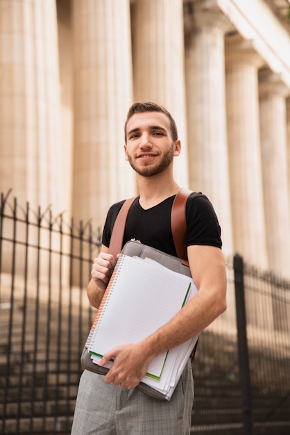 Guy standing next to university low angle view