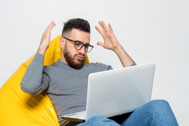 Guy suprised while sitting on yellow pouf chair