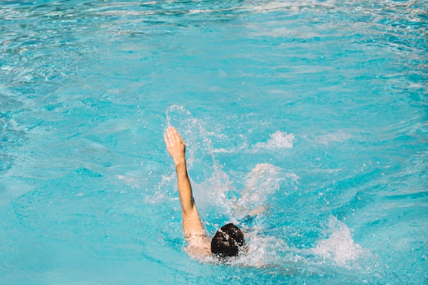 Free photo guy swimming backstroke in water