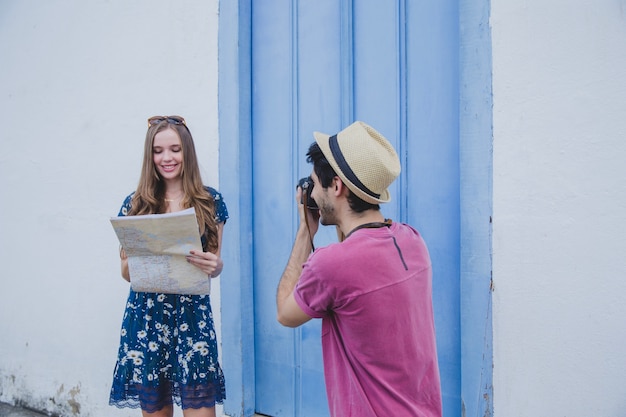 Free photo guy taking photo of girlfriend holding map