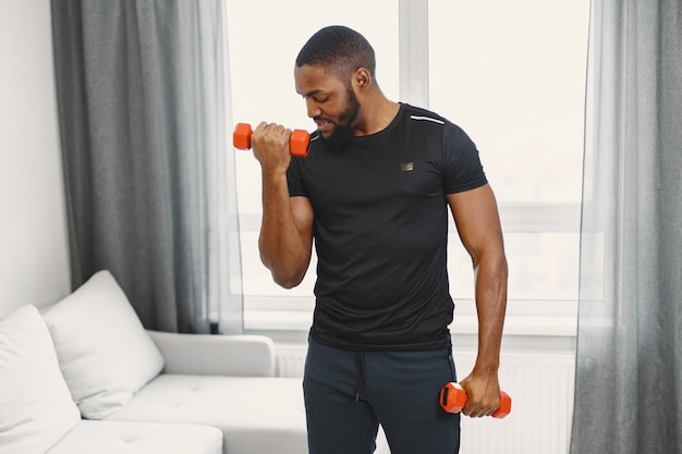 Guy training at home with dumbbells