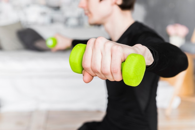 Foto gratuita ragazzo allenamento e sollevamento manubri verdi