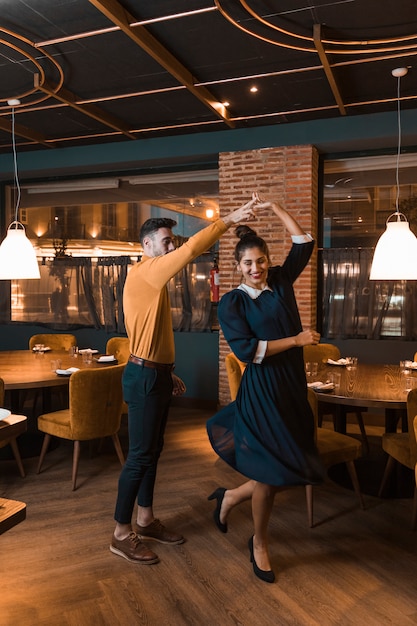 Free photo guy whirling cheerful lady in restaurant