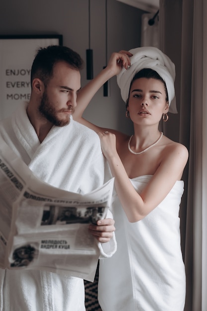 Free photo guy in a white coat and a woman in a towel