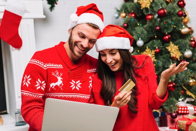 Guy with laptop near lady with credit card