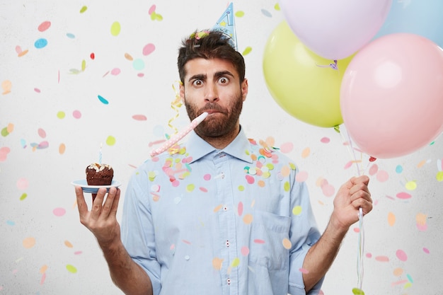 Free photo guy with party hat and confetti