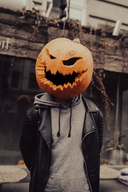 Guy with a pumpkin head poses for the camera