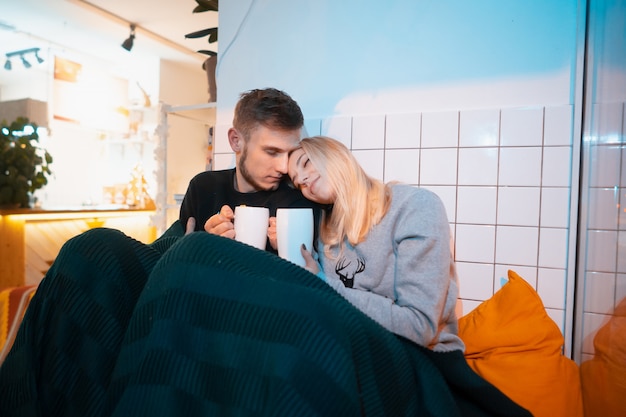 Ragazzo con una giovane donna che beve tè e caffè caldi